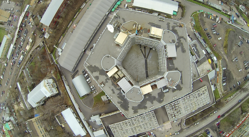 Aerial view of a five-sided building with a central courtyard, ringed by warehouses and parking lots