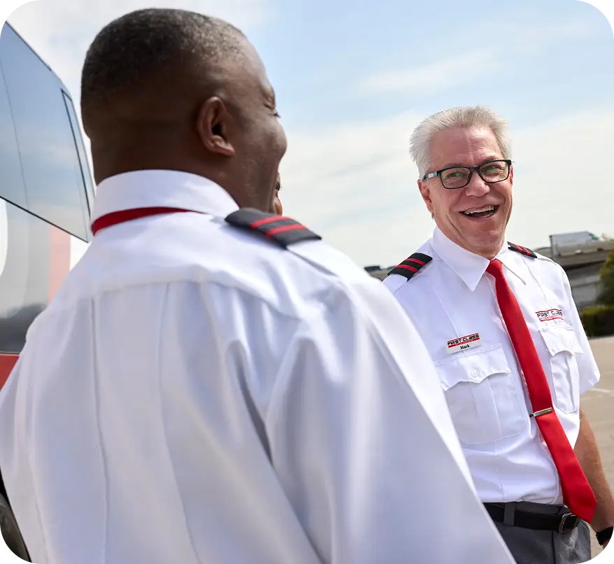 Two First Class Transportation drivers in uniform talking outdoors