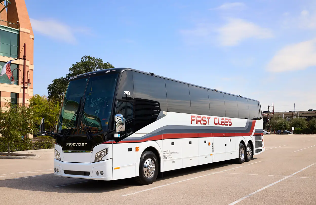 White First Class Transportation Prevost motorcoach parked in a lot