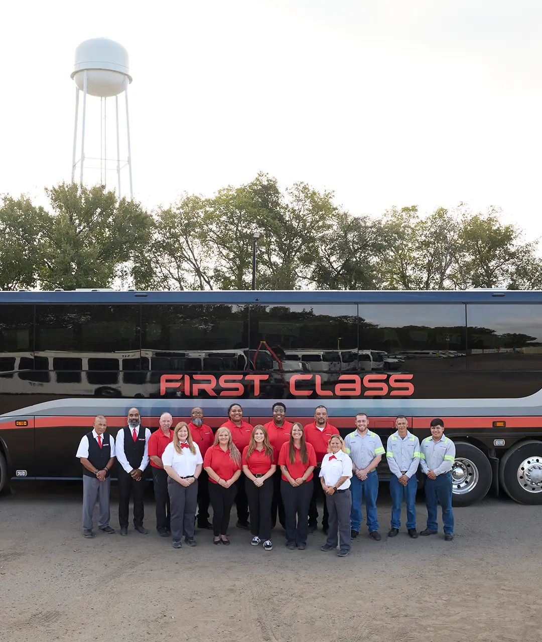 First Class Transportation team standing in front of a motorcoach at the company yard