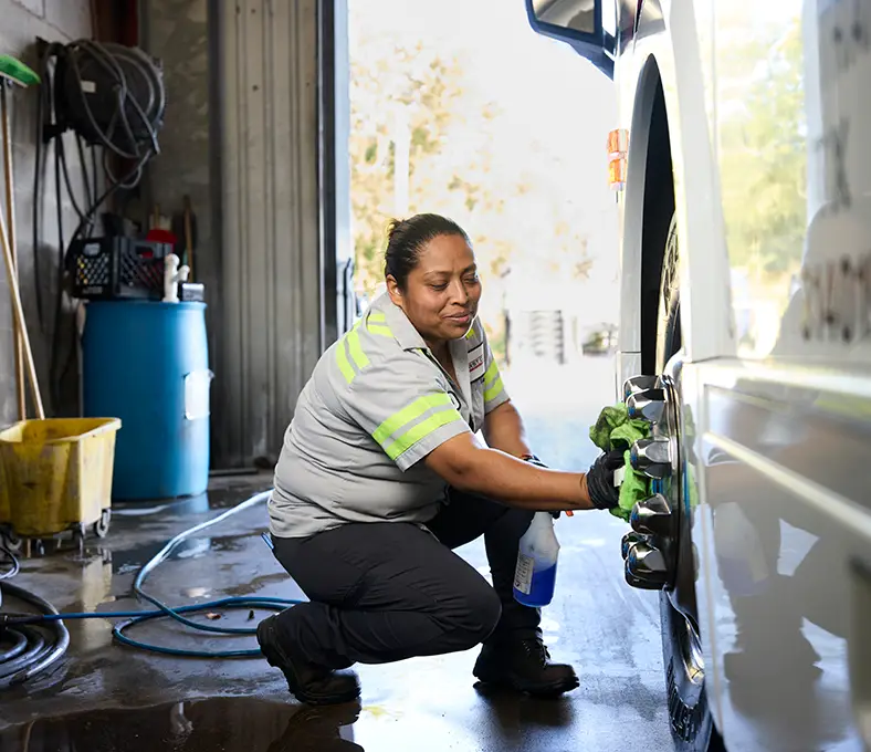 First Class Transportation technician cleaning a vehicle wheel in the maintenance garage