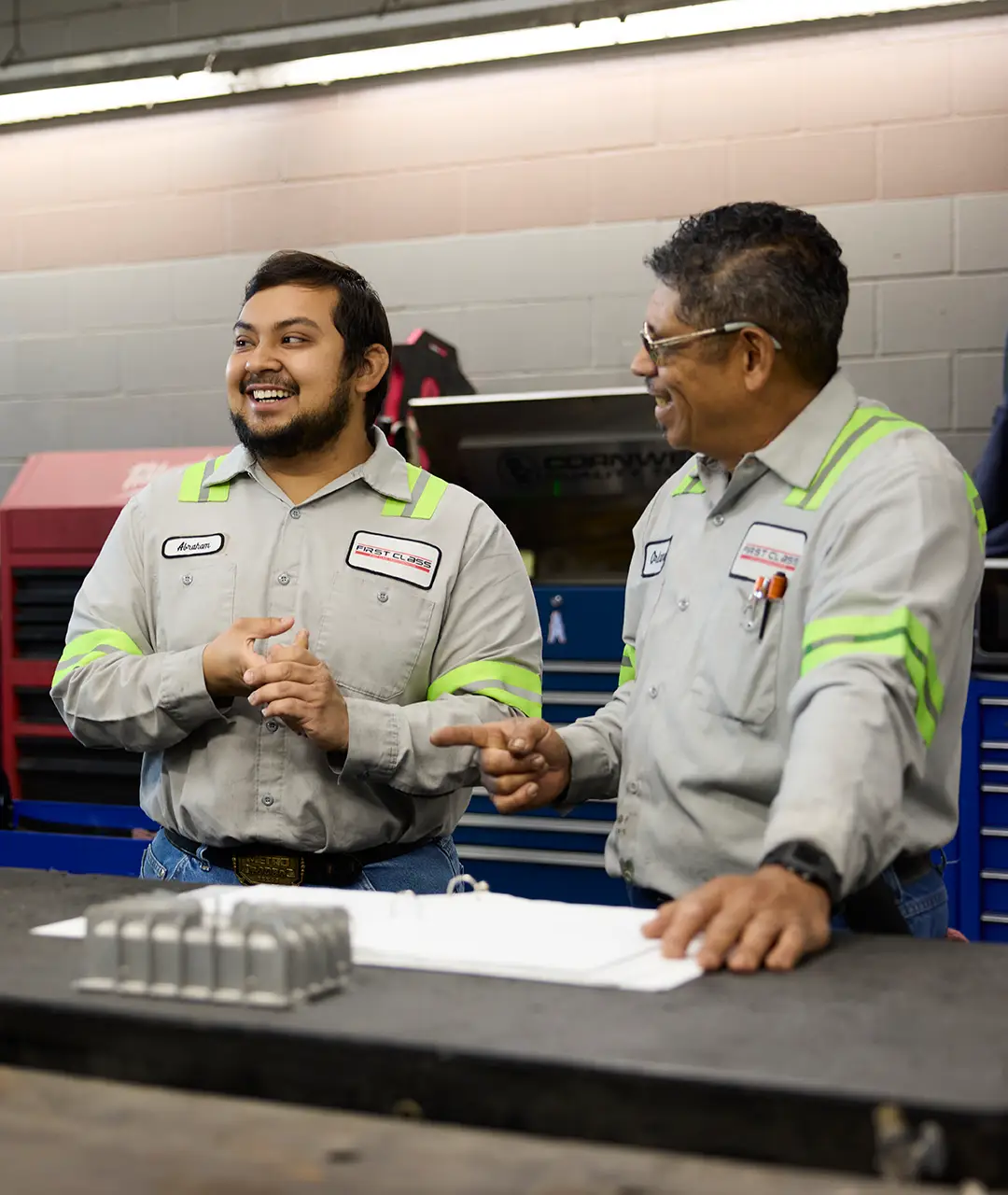 Two First Class Transportation mechanics talking in the maintenance shop