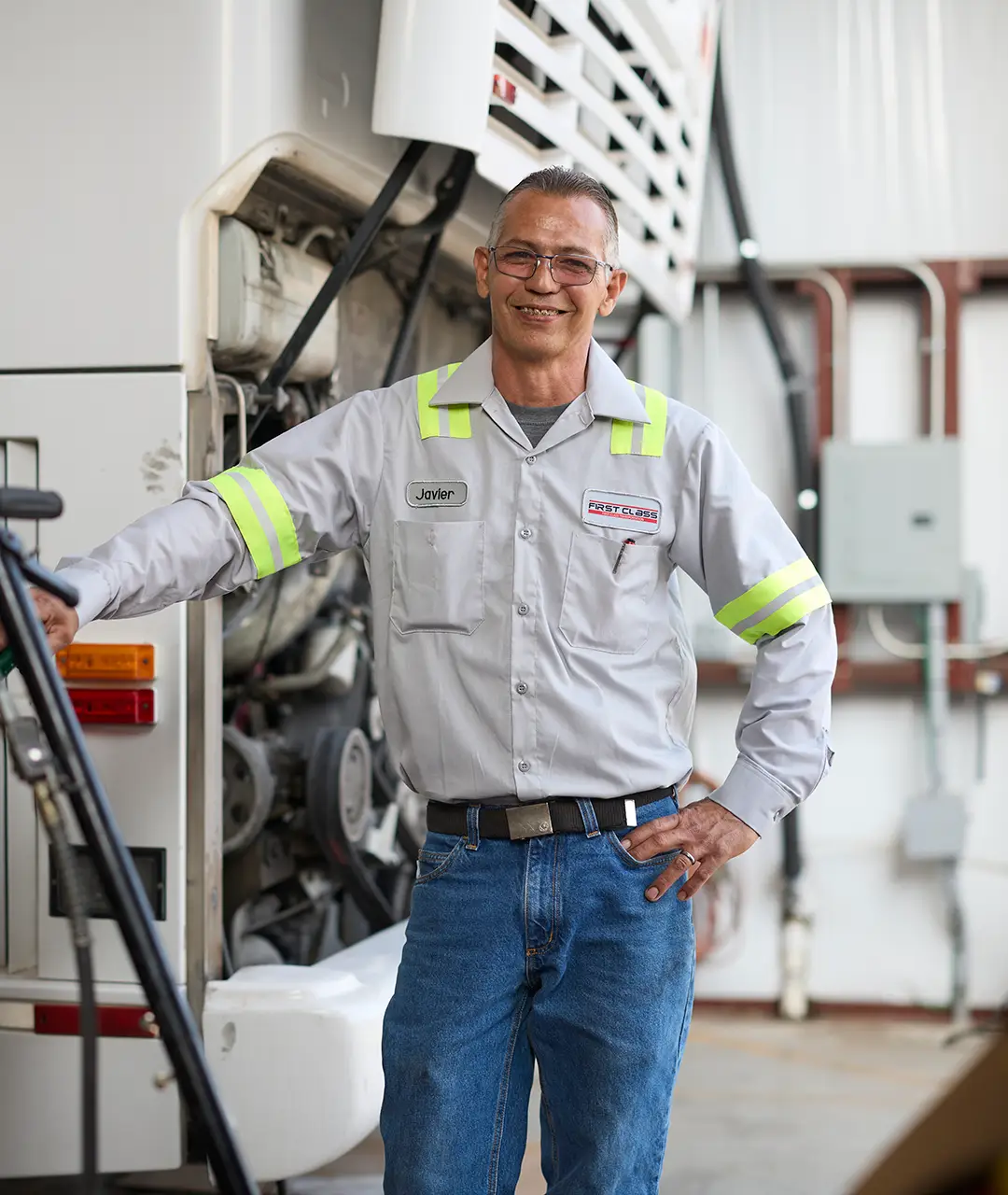 First Class Transportation mechanic standing beside an open motorcoach engine bay