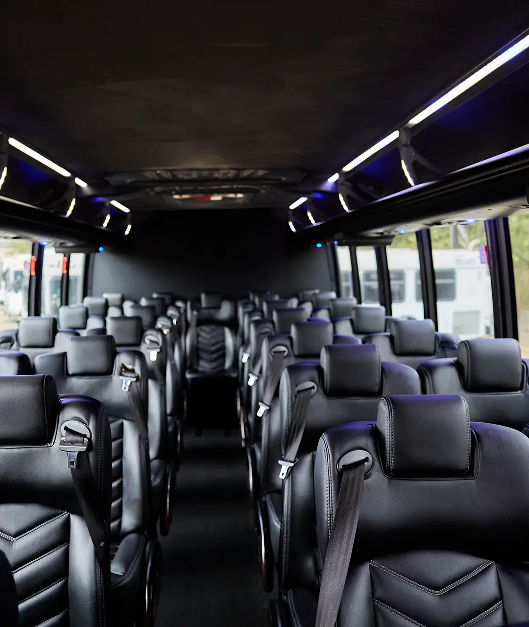 Rows of black leather seats inside a First Class Transportation motorcoach