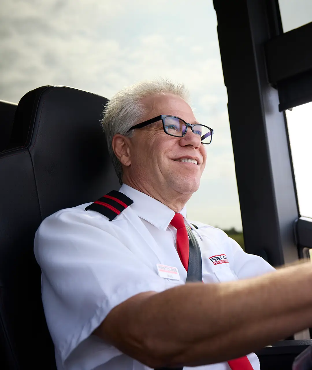 First Class Transportation driver in uniform at the wheel of a motorcoach