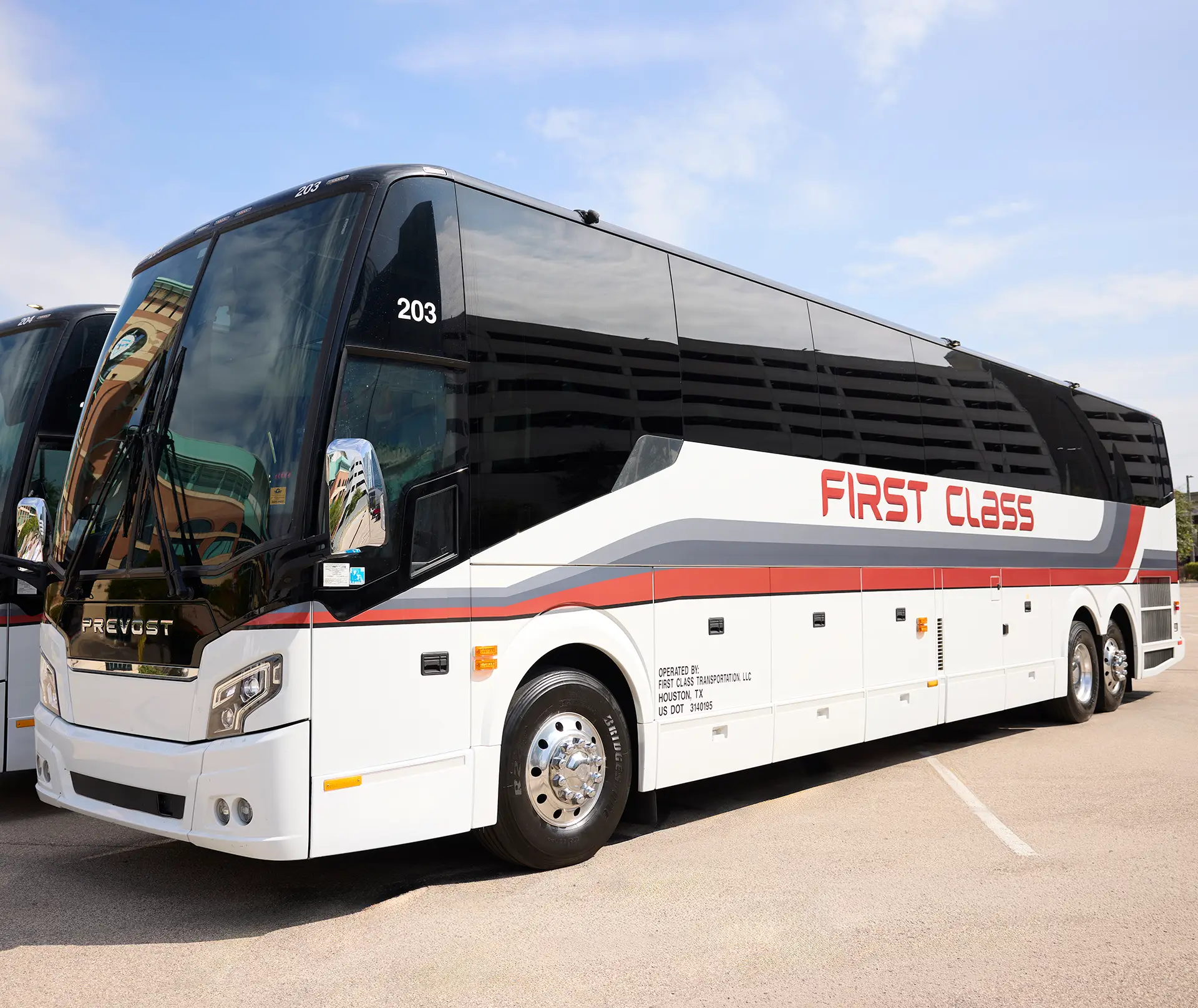 White First Class Transportation Prevost motorcoach with red First Class lettering parked in a lot