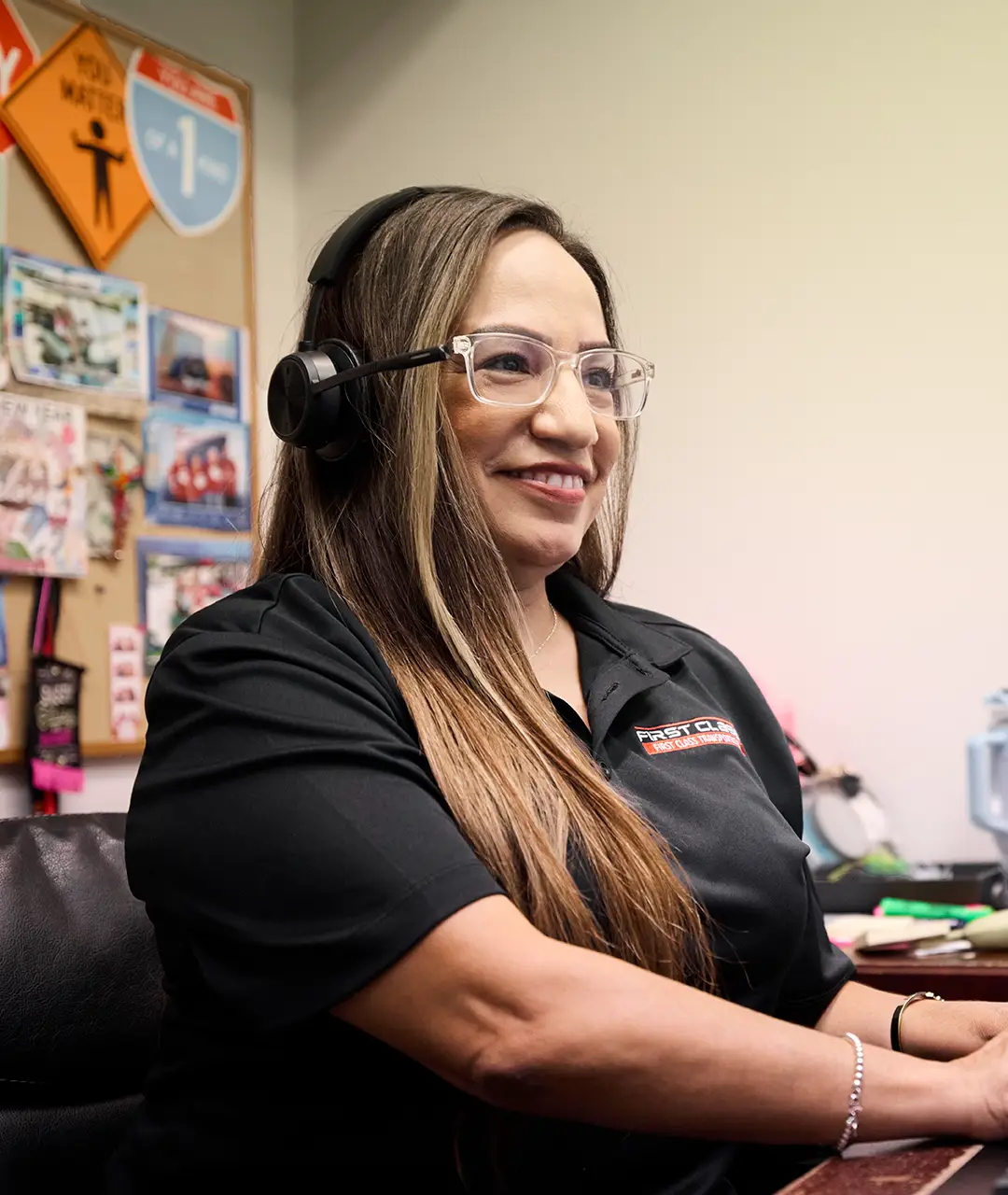 First Class Transportation reservations agent wearing a headset at her desk