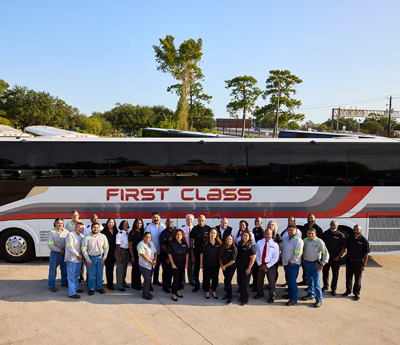 First Class Transportation team standing in front of a white First Class motorcoach
