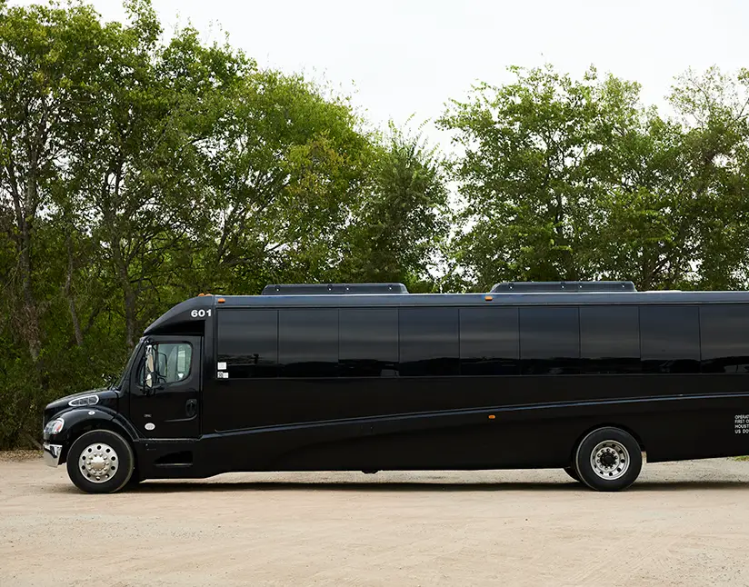 Black First Class Transportation minibus parked on gravel