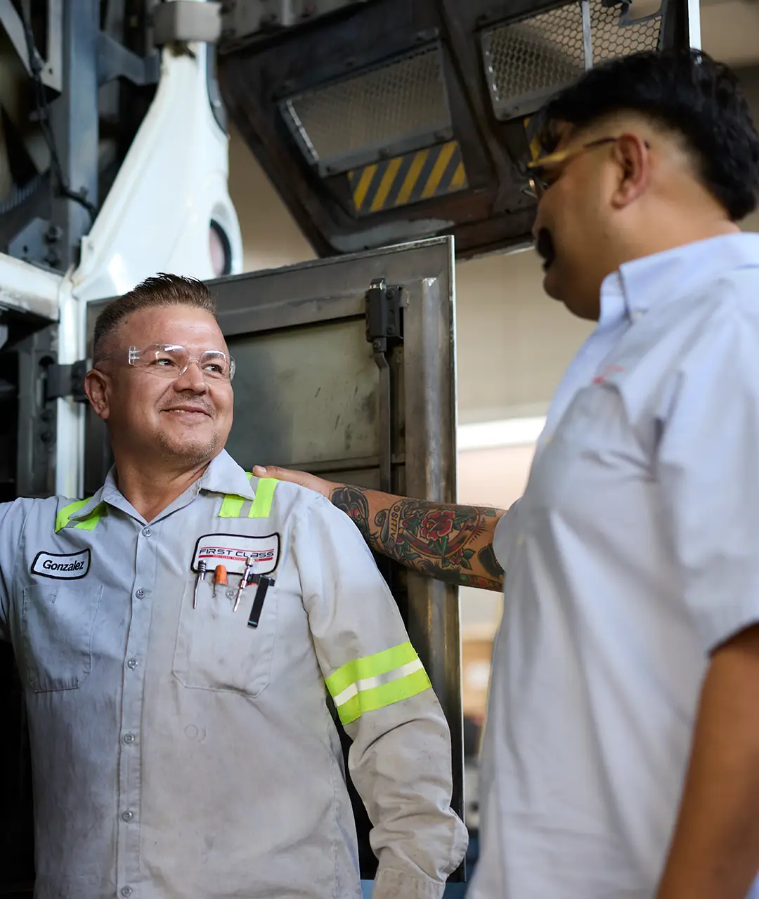 Two First Class Transportation maintenance technicians talking in the shop