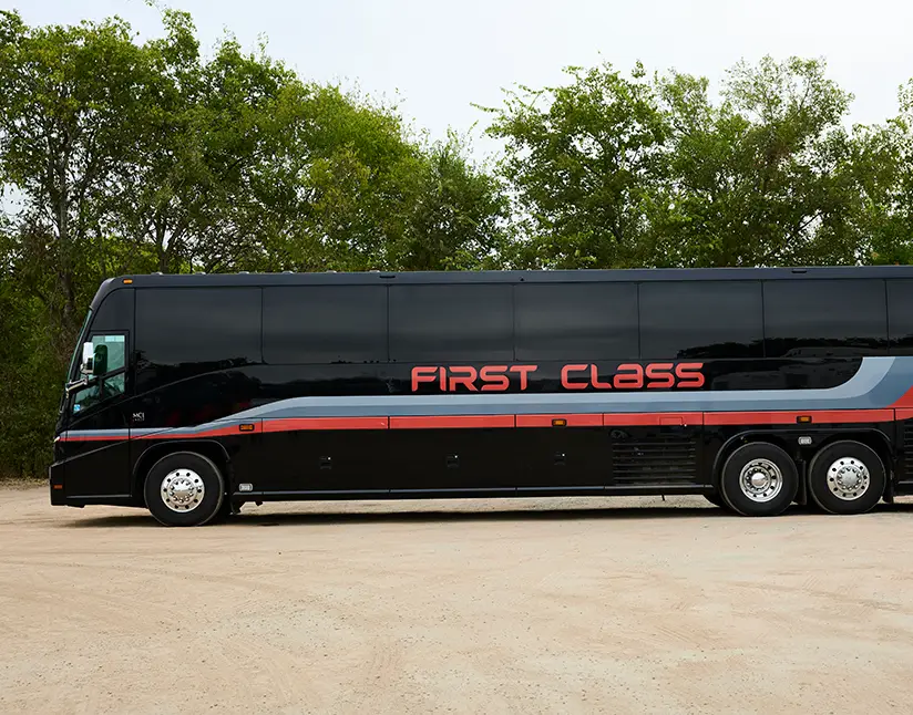 Black First Class Transportation mid-size MCI motorcoach parked on gravel