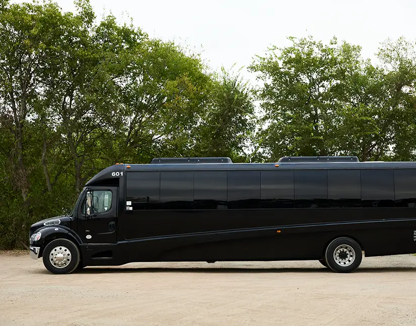 Black First Class Transportation minibus parked on gravel