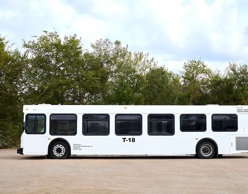 White First Class Transportation transit bus parked on gravel