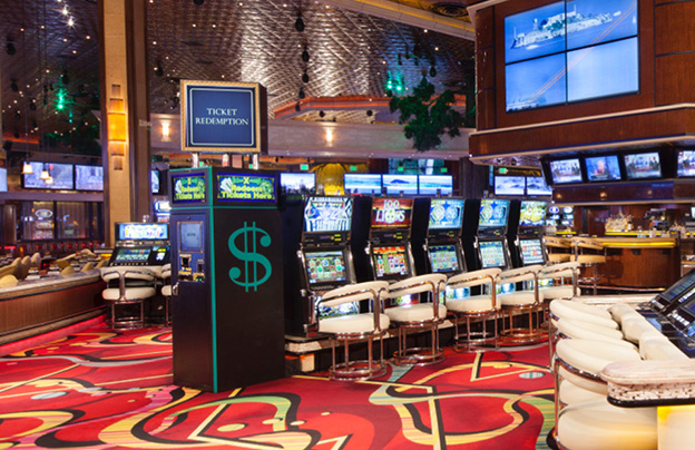 Paragon Casino Resort gaming floor with rows of slot machines and a ticket redemption kiosk